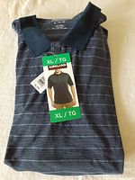 Folded navy blue men’s short sleeve polo shirt with thin horizontal gray stripes, showing size XL tag and manufacturer’s tags attached.