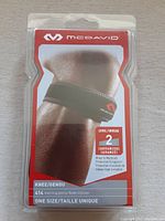 Front view of sealed McDavid 414 knee strap package showing brand, model, and key features.