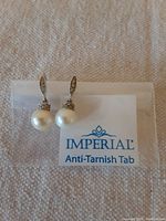 Pair of earrings showing entire drop and presentation with anti-tarnish tab