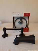 Photo of Pfister Breckenridge Towel Ring BRB-BC0B in original packaging, with towel ring in dark finish visible