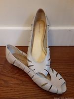 Top and side view of white leather upper ladies shoes showing cutout design and peep toe style, size 5.5 M
