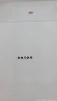 Five small round sapphires with multicolored (teal blue and green) flashes, arranged in line on white background.