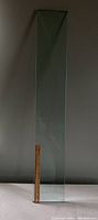 Single heavy glass shelf standing vertically next to a 12 inch ruler showing the approximate length (34 inches) and width (6.5 inches).