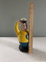 Full figure standing about 7 inches tall next to ruler