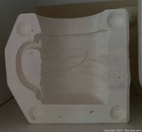 White ceramic mold for a jeans mug, showing interior with handle and details for ceramic casting.
