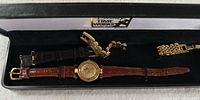 Disassembled view of the vintage Disney Mickey Mouse wristwatch with brown leather strap, and two additional watch bands (black leather and gold-tone metal link) in Disney Time Works presentation box.