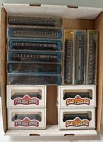 Top view of multiple N scale passenger train cars in clear plastic cases and boxed freight cars labeled Freight Cars and Old Timers.