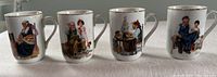 Front side showing four cups displaying Norman Rockwell illustrations with vintage family scenes and individuals in period clothing.