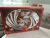 Box showing 3 new in box decorative party platters designed with etched or cut patterns.