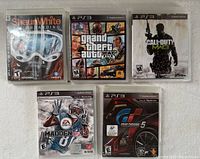 Photo of five PlayStation 3 game cases including Shaun White Snowboarding, Grand Theft Auto V, Call of Duty: MW3, NFL 13, and Gran Turismo 5.