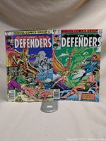 Two Marvel comic books from The Defenders series, issues 79 and 83, standing upright with colored cover art.