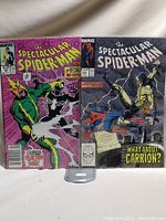 Two issues of The Spectacular Spider-Man comics, #134 and #135, bagged and boarded, displayed side by side.