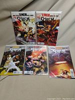 Shows all five X-Men Schism comic books standing upright, bagged and boarded.