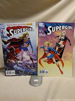 Front view of Supergirl comic issues #1 and #5 showing character artwork and condition.