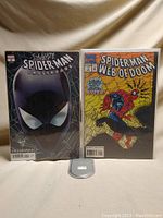 Photo showing both comic books side by side, front covers visible, bagged and boarded.