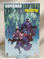 Front cover of the comic book showing Superman and Batman against Alien and Predator figures