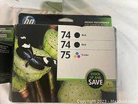 Front view of HP 74/74/75 Ink Refill 3-Pack packaging with butterfly and green plant background showing the cartridge types and Save sticker.