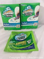 Photo showing 2 green boxes of Scrubbing Bubbles Toilet Cleaning Gel and 1 green packet of Flushable Wipes on white background