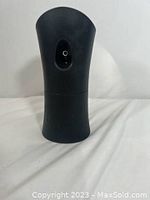 Front angled view of black automatic AirWick AutoFresh air freshener dispenser showing nozzle opening at top front.