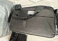 Black Bubbly Bambina diaper bag backpack closed showing front exterior with logo and handles.
