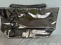 Front view of the black glossy DKNY Weekender Bag showing large DKNY logo on the side and top handles.