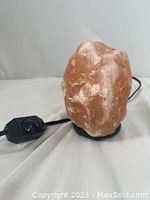 Large Himalayan rock salt lamp with black electrical cord and inline on/off switch visible.