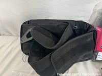 Two black adjustable back braces sized 2XL, with Velcro and buckle straps for adjustable support.
