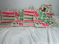 Four reusable canvas shopping bags displayed side by side, showing colorful floral and stripe design on front.