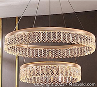 Photo of two circular crystal chandeliers suspended, showing intricate crystal lattice design within gold-tone metal frame.