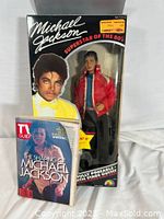 Photo of original boxed Michael Jackson 12-inch Beat It doll standing upright with a TV Guide magazine in front.