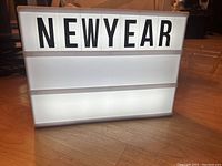 Illuminated white lightbox with letters spelling 'NEW YEAR' turned on and lit up.
