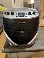 Front view of the EMEASON karaoke machine showing control knobs, digital display, and speaker grille with logo