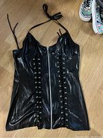 Black faux leather halter dress with front zipper and vertical lace-up accents on sides.