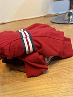 Folded red long sleeve shirt with white, navy, and red stripes visible