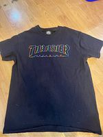 Black Thrasher Magazine T-shirt with rainbow outlined logo printed on chest
