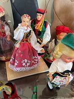 Close-up of detailed dolls in traditional European costumes showing embroidery, lace, and fabric colors