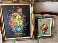 Two vintage floral paintings displayed side by side, showing size and frame details