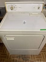 Overall view of white Kenmore dryer with closed front door, showing unit condition and size.