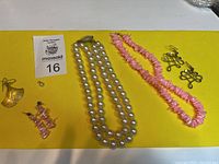 Full view of all jewelry items on yellow background with auction lot card