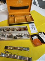 Full display of seven sets of cuff links and tie pins, two metal watch bands, Buxton keyholder, and velvet-lined snap-close case.