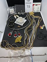 Fully displayed set of vintage jewelry including necklace, earrings, brooches, pin, bracelet arranged on black surface