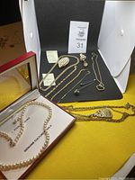 Multiple jewelry pieces arranged on black mat and yellow surface