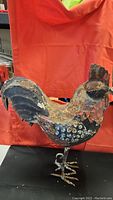 Front and side views of the rustic metal rooster decoration showing its weathered, rusty condition and detailed metal construction.