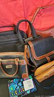 Photo showing a group of 7 mixed bags and purses with various colors, styles, and brands against a red backdrop.
