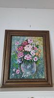Front view of floral painting showing peonies in glass vase with colorful background and ornate gold frame