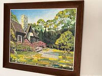 Framed oil painting depicting a house with spring garden landscape, showing the full artwork and frame.