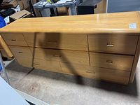 Photo of the full dresser showing wooden finish, six drawers with brass handles.