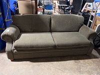 Front view of green upholstered sofa by Simmons showing two seat cushions and two back cushions with rolled arms.