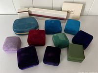 Full view of 10 jewelry boxes including velvet-covered and vintage cardboard branded boxes