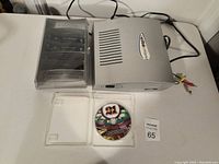 Game Wave console with wireless remotes in clear holder, and game disc in case.
